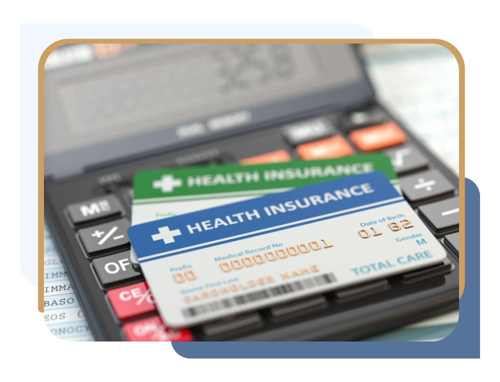 Health insurance cards sitting on a calculator.