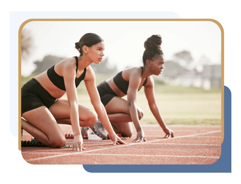 Two female track athletes at the starting blocks before a race